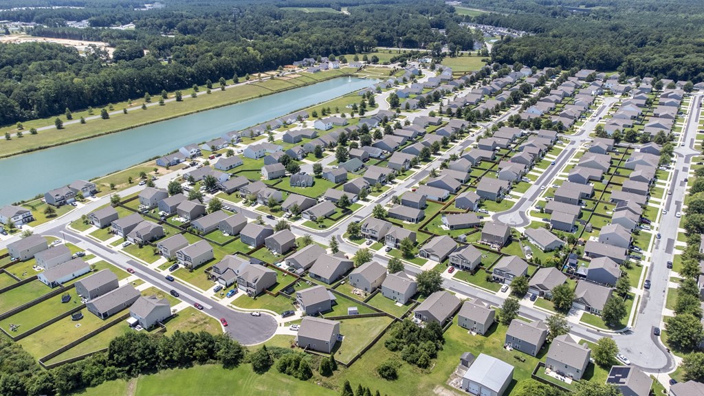 A bird's eye view of a residential neighborhood with houses and a river.