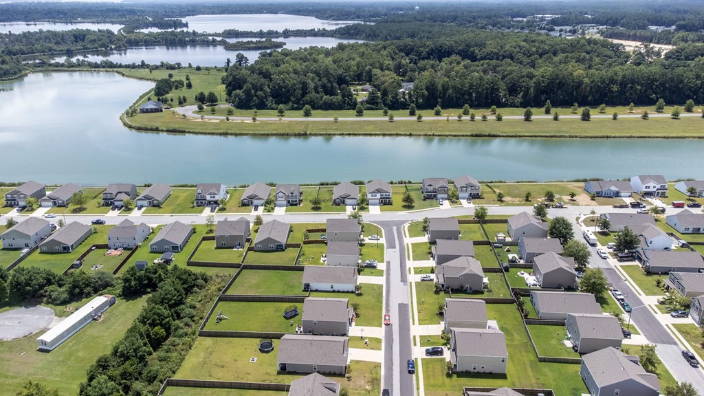 A bird's eye view of a residential area with houses and a lake.