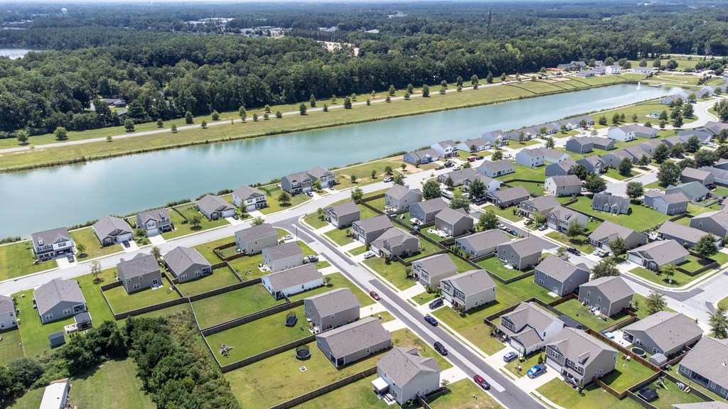 A residential area with houses and a river in the background.