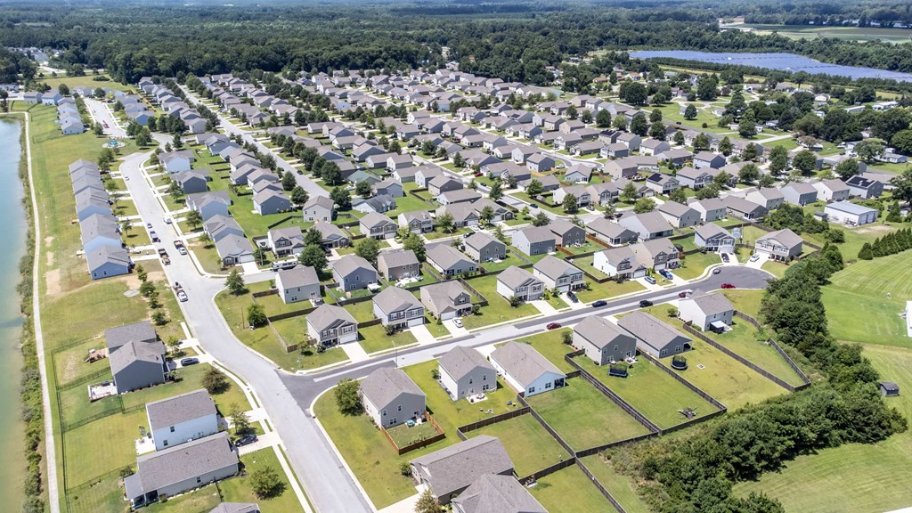 A bird's eye view of a residential neighborhood with houses and a river.