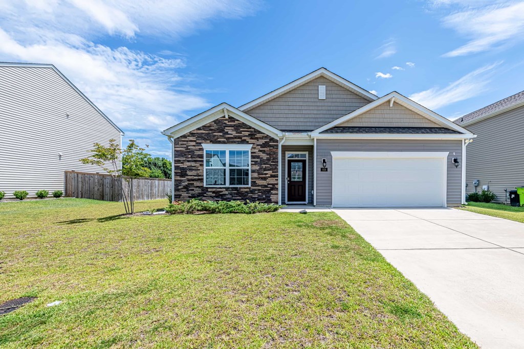 A house with a garage and a driveway in front.