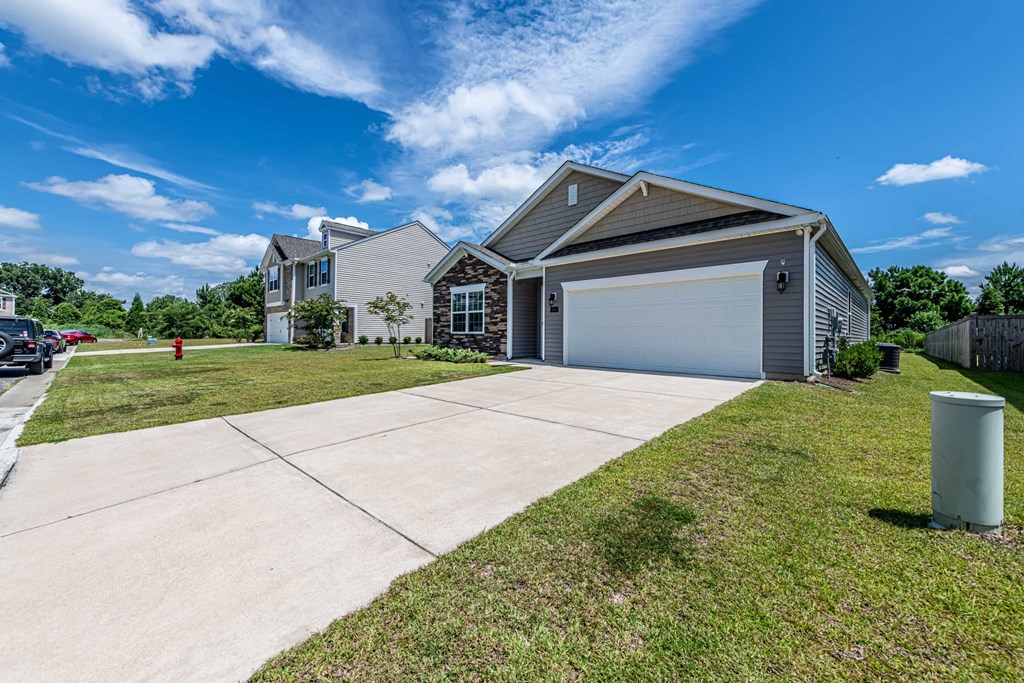 A house with a garage and a driveway in front of it.