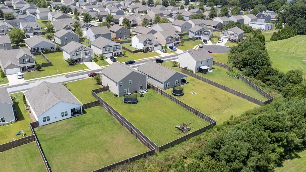A bird's eye view of a suburban neighborhood with houses and lawns.