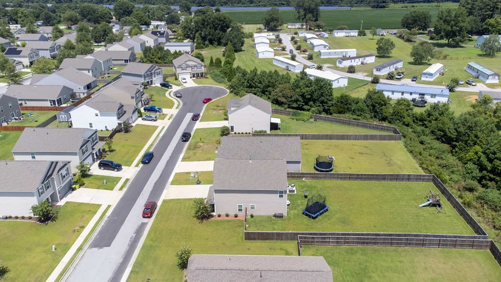 A bird's eye view of a residential area with houses and a road.