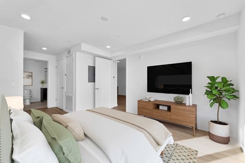 A modern living room with a white sofa and a wooden entertainment center.