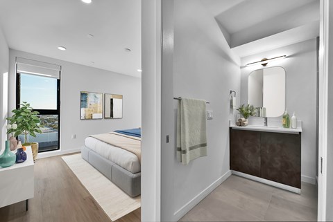 A modern bedroom with a large bed and a separate bathroom area.