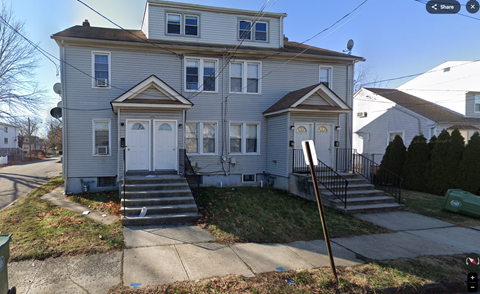 A two-story house with a grey facade and white trim.