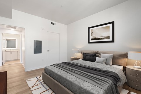 A bedroom with a large bed and a painting on the wall.