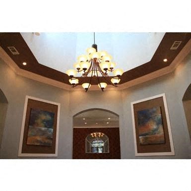 a chandelier hanging from the ceiling in a room with paintings