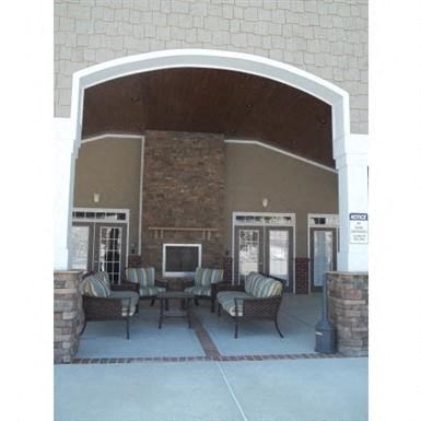 a patio with chairs and a table in front of a building
