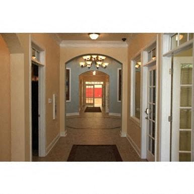 a long hallway with doors and a chandelier