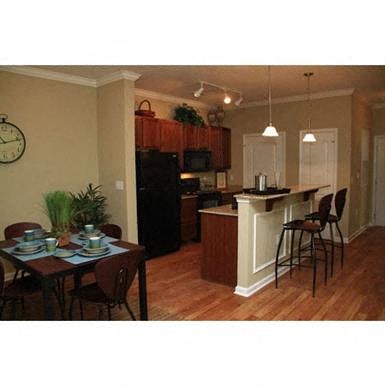 a kitchen and a dining room with a table and chairs