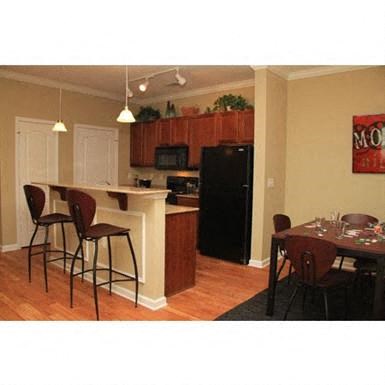 a kitchen and a dining room with a table and chairs
