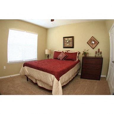 a bedroom with a bed and a dresser and a window