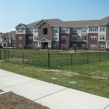 an apartment building with a fence in front of it