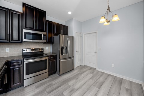 A kitchen with dark brown cabinets and stainless steel appliances.