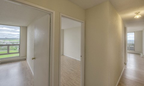 an empty living room and hallway with an open door