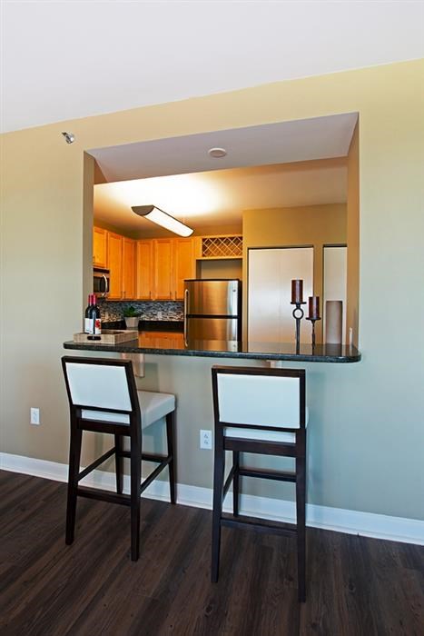 a kitchen with a bar with two chairs