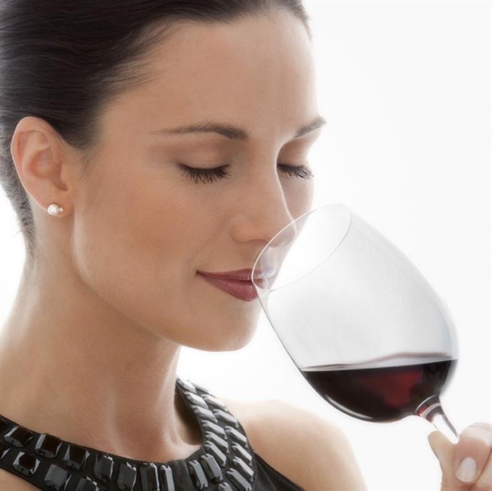 a woman drinking a glass of red wine