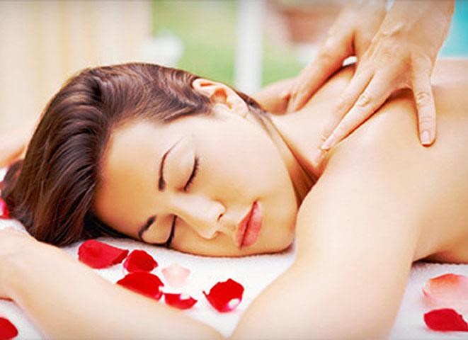a woman laying on a massage table with her hands on her back