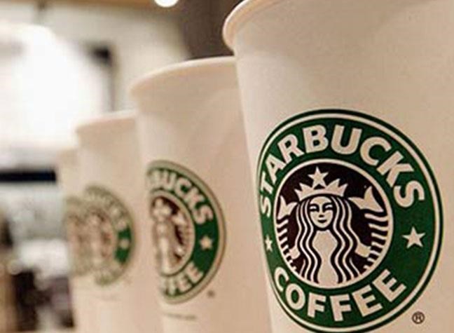 two starbucks coffee cups sitting on a table