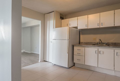 a kitchen with white cabinets and a sink and a refrigerator