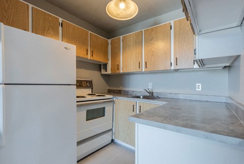 a kitchen with white appliances and wooden cabinets