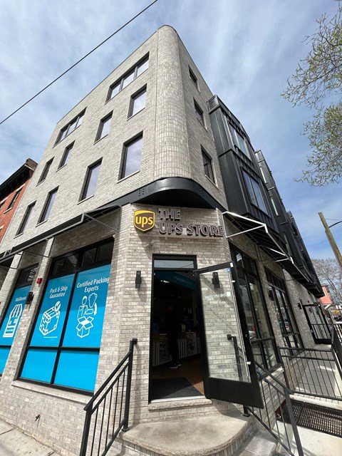 A UPS Store is located in a building with a stone facade.
