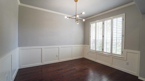 A room with a window and a chandelier.