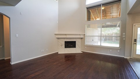 A room with a fireplace and wooden floors.