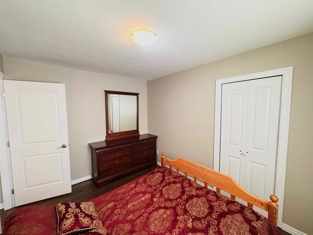 A bedroom with a bed, dresser, and mirror.
