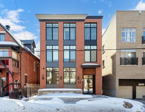 A red brick building with a black railing in front.