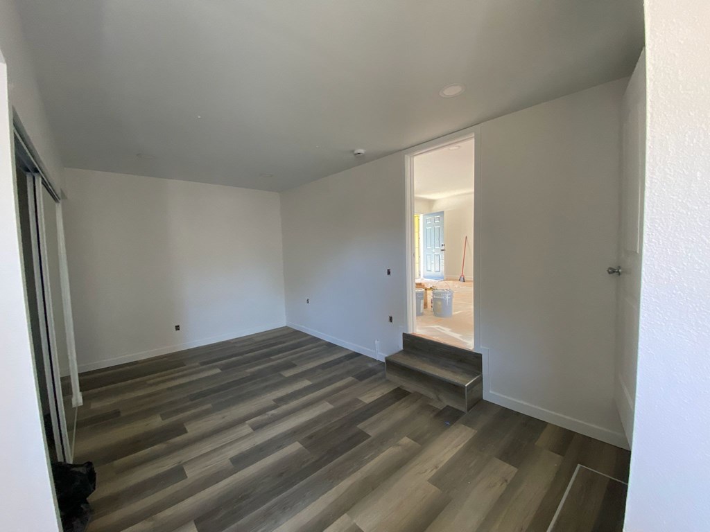 A room with a wooden floor and white walls.