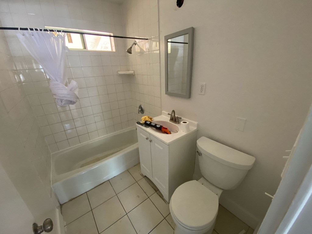 A white bathroom with a toilet, sink, and tub.