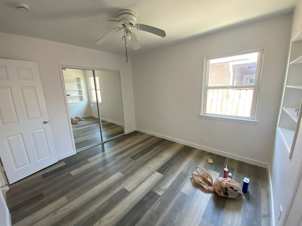 A room with a ceiling fan and a window.