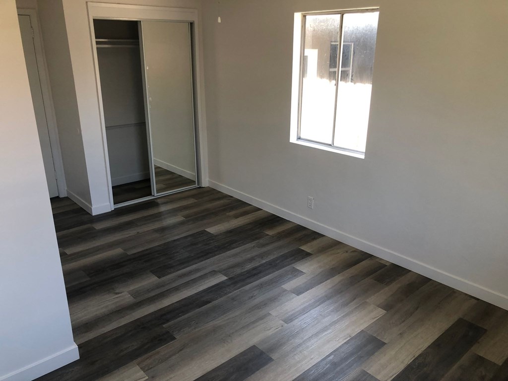 A room with a wooden floor and a window.