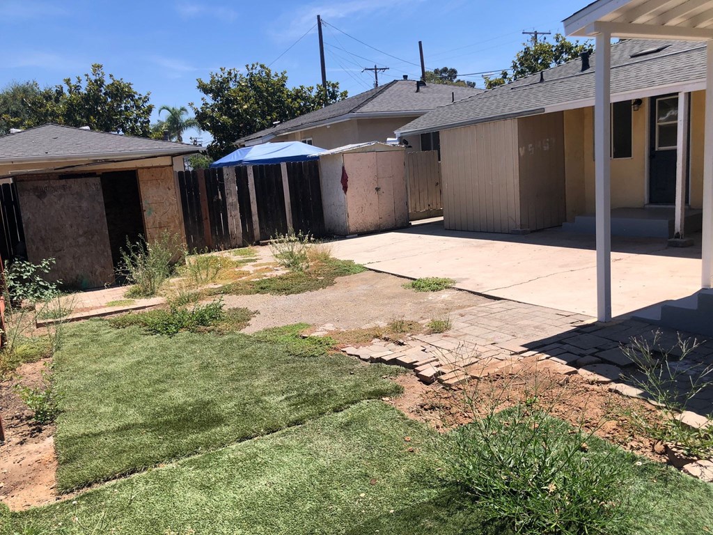 A backyard with a lawn and a shed.