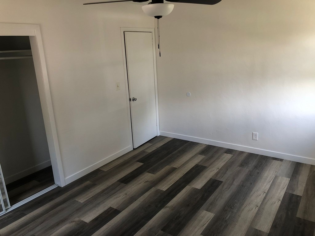 A room with a ceiling fan and a door.