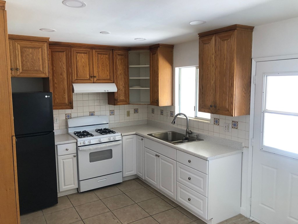 A kitchen with white appliances and wooden cabinets.