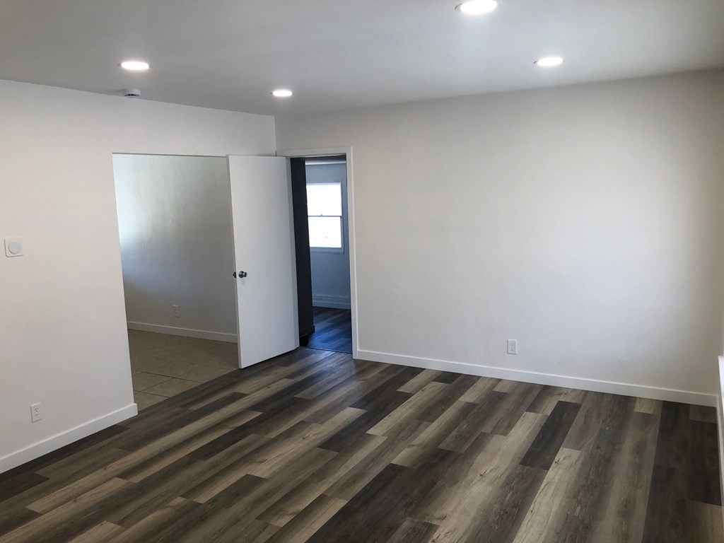 A room with wooden flooring and white walls.