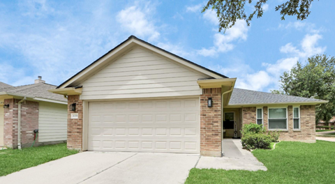 A house with a garage door and a driveway.