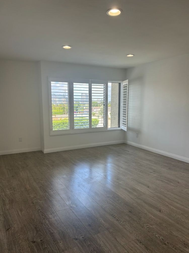 A room with a window and wooden flooring.
