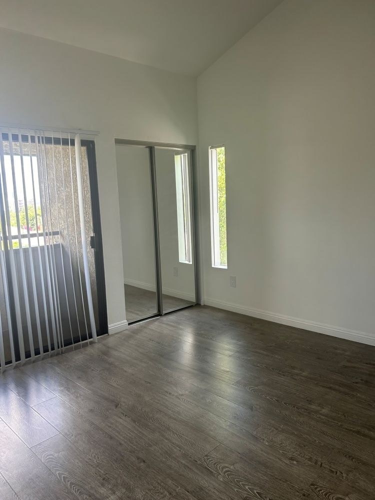 A room with a sliding door and a wooden floor.