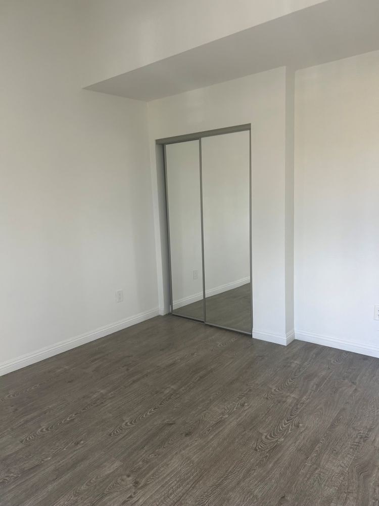 A room with a sliding glass door and wood flooring.