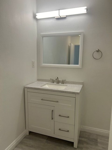 A bathroom with a sink and a mirror.