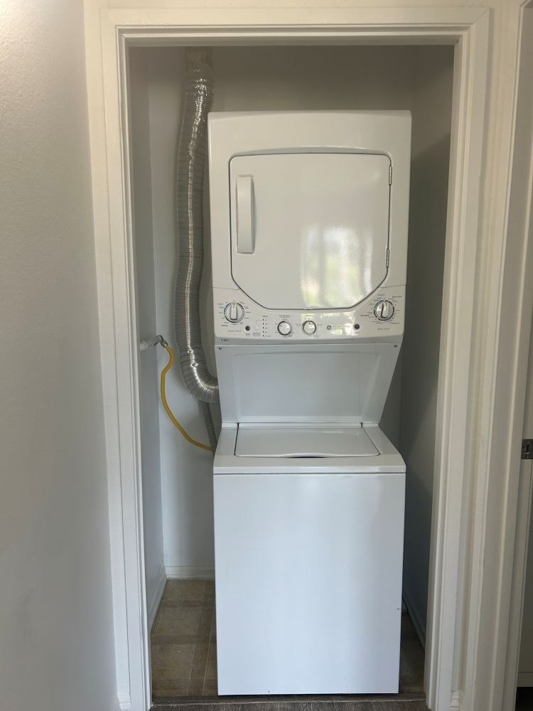 A white washing machine is in a small doorway.