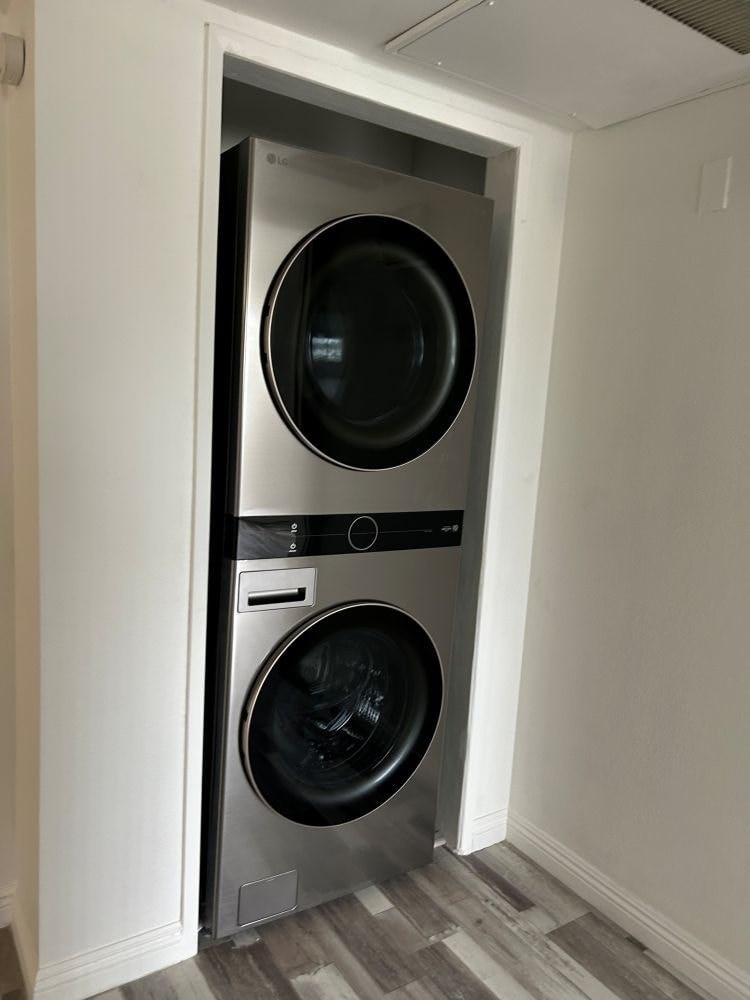 A modern laundry room with a washer and dryer built into the wall.