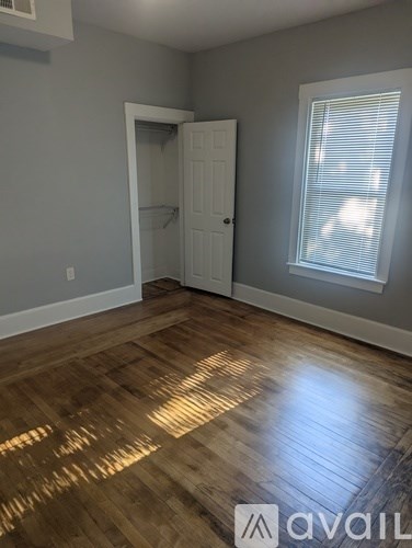 A room with wooden flooring and a white door.