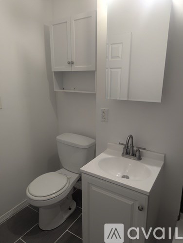 A white toilet and sink in a small bathroom.