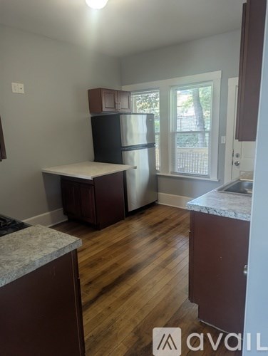 A kitchen with wooden floors and a marble counter.